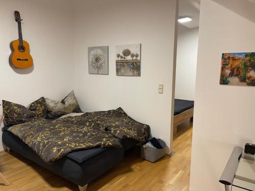 a bedroom with a bed and a guitar on the wall at Ruhiges Dachgeschoß CityApartment im Zentrum Wiens in Vienna