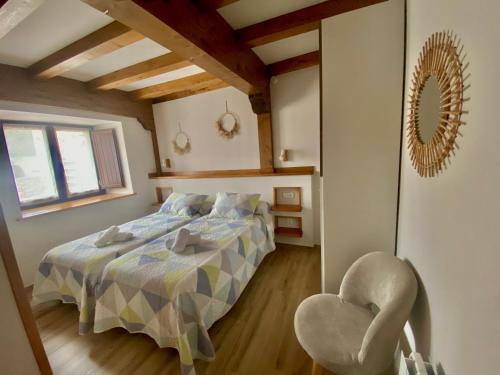 a bedroom with a bed and a chair at Apartamentos La Ventana de Mogrovejo in Mogrovejo