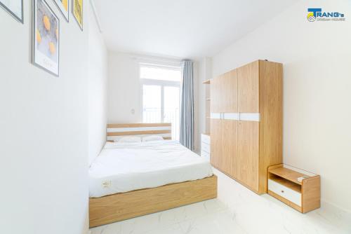 a bedroom with a bed and a wooden cabinet at Trang Dream House Phan Rang in Kinh Dinh