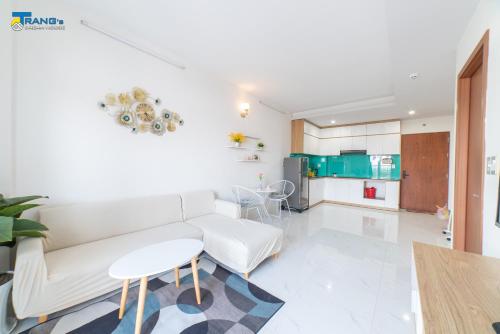 a living room with a white couch and a table at Trang Dream House Phan Rang in Kinh Dinh