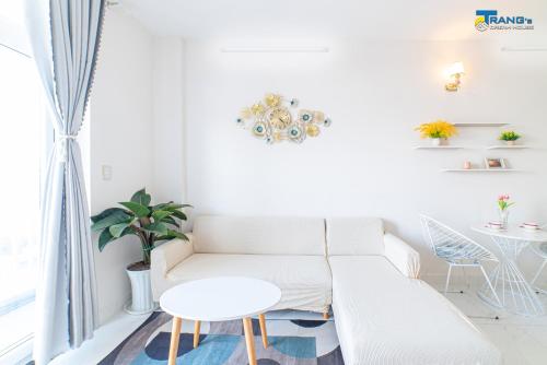 a white living room with a couch and a table at Trang Dream House Phan Rang in Kinh Dinh