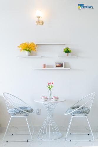 a white table with two chairs and a table with plants at Trang Dream House Phan Rang in Kinh Dinh