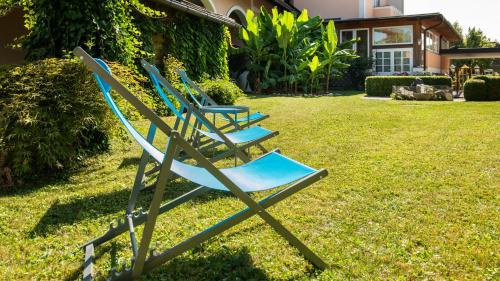 a group of blue chairs sitting in the grass at Hotel Altneudörflerhof in Bad Radkersburg
