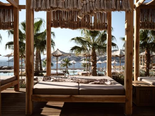 a bed in a room with a view of the beach at Seaside A Lifestyle Resort - Adults Only in Agia Pelagia