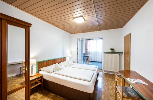ein Schlafzimmer mit einem großen weißen Bett in einem Zimmer in der Unterkunft Hotel Altneudörflerhof in Bad Radkersburg