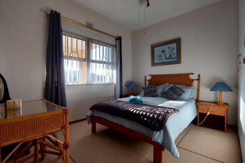 Un dormitorio con una cama y un escritorio y una ventana. en Margate Happy Place, en Margate