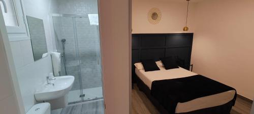 1 dormitorio con cama, lavabo y ducha en ROOMS Los MONTES en Granada