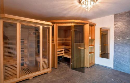 a walk in closet with wooden cabinets and a chandelier at Beautiful Home In St, Gallenkirch With 6 Bedrooms, Sauna And Wifi in Aussersiggam