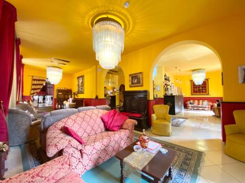 蒙特卡蒂尼泰爾梅的住宿－HOTEL RINASCIMENTO，客厅设有粉红色的沙发和黄色的墙壁。