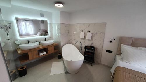 a bathroom with two sinks and a large mirror at Apartments ANA Karlobag in Karlobag