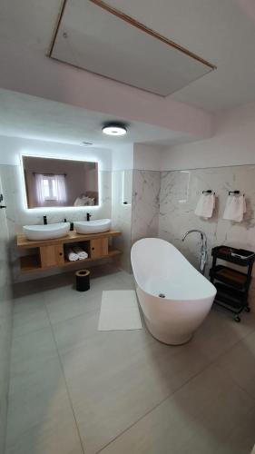 a bathroom with two sinks and a large tub at Apartments ANA Karlobag in Karlobag