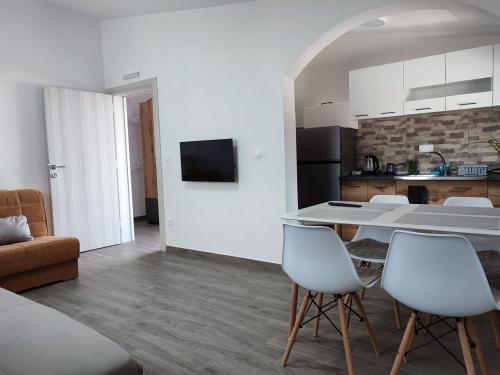 a kitchen and a living room with a table and chairs at Sayohat Apartments in Dobra Voda
