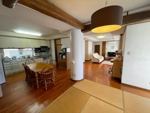 a kitchen and living room with a table and chairs at 民泊ありんくりん in Haebaru