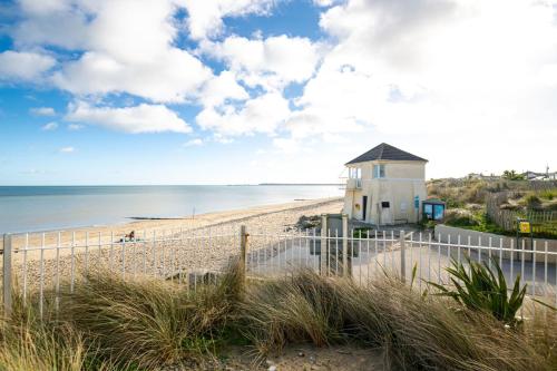 a lighthouse on a beach with the ocean at Seabury Holiday Home, Rosslare Strand, County Wexford - Sleeps 7 in Rosslare