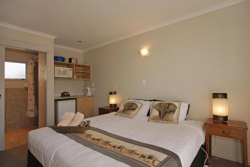 a bedroom with a large white bed with two pillows at Big Five Motel in Palmerston North
