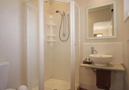 a bathroom with a shower and a sink at Big Five Motel in Palmerston North