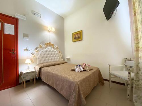 a bedroom with a bed and a chair at HOTEL RINASCIMENTO in Montecatini Terme