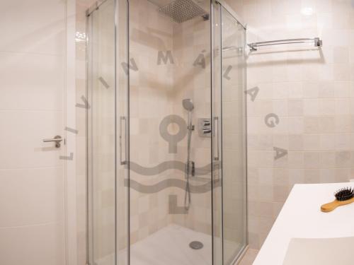 a shower with a glass door in a bathroom at LivinMálaga Los Álamos Suites in Torremolinos