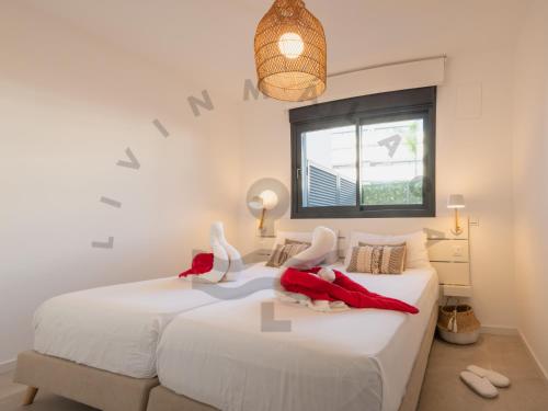 2 witte bedden in een slaapkamer met een raam bij LivinMálaga Los Álamos Suites in Torremolinos