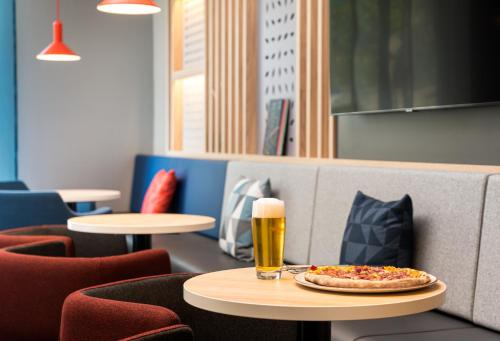 a pizza sitting on a table with a glass of beer at Holiday Inn Express - Rosenheim by IHG in Rosenheim