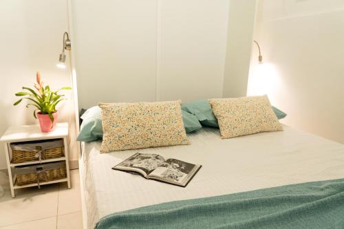 Una cama con dos almohadas y un libro. en Unique 1 bedroom in hearth of old city Valetta en La Valeta