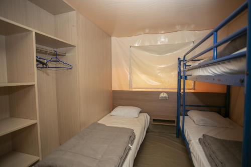 a small room with two bunk beds and a window at La Bastide in Mazères