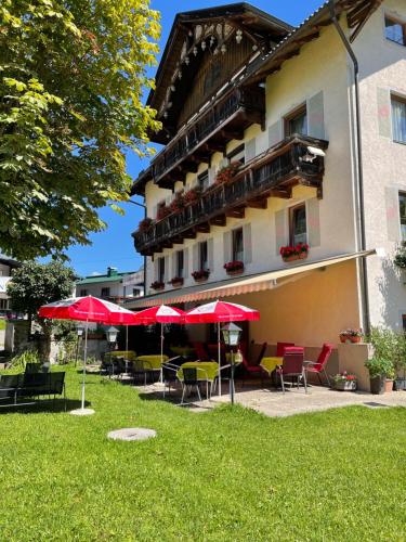 a hotel with tables and chairs and umbrellas at Goldener Adler in Scharnitz