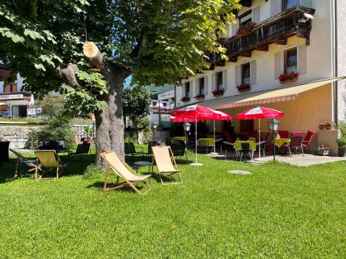 a group of chairs and umbrellas next to a building at Goldener Adler in Scharnitz