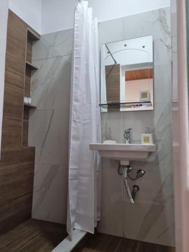 W łazience znajduje się umywalka i lustro. w obiekcie B Vishe Guest House w Gjirokastrze