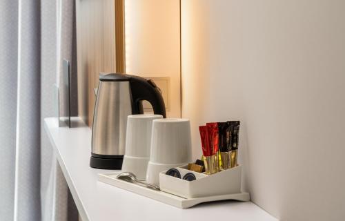 a shelf with a coffee maker and books on it at Holiday Inn Express - Rosenheim by IHG in Rosenheim