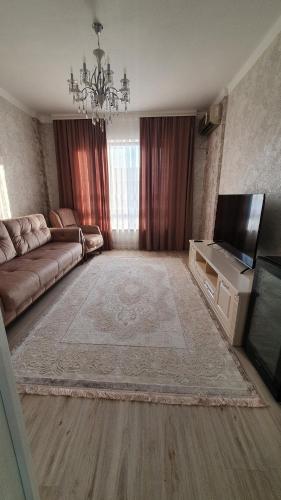 un soggiorno con divano e TV a schermo piatto di KERUEN SARAY APARTMENTS 6/2 a Türkistan
