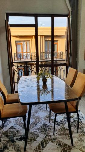 a table and chairs in a room with a balcony at KERUEN SARAY APARTMENTS 6/2 in Türkistan