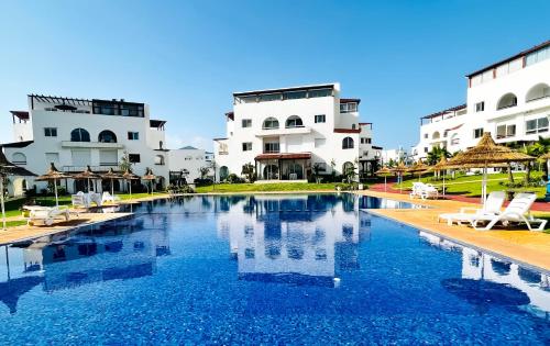 een zwembad voor twee witte gebouwen bij Smart Holiday Cabo Negro in Cabo Negro