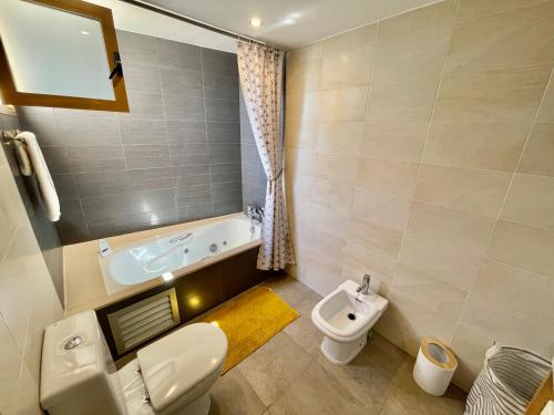 a bathroom with a toilet and a sink and a tub at Modern 2-Floor Penthouse with Sea Views - Sleeps 7 in Finestrat