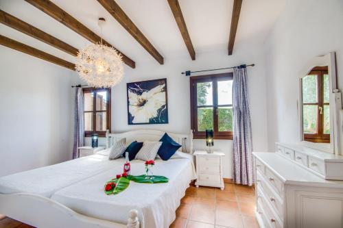 sypialnia z białym łóżkiem i żyrandolem w obiekcie Ideal Property Mallorca - Es Puput w mieście Petra