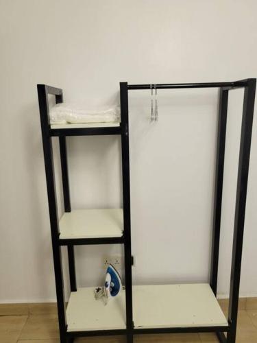 a black shelving unit with three tiers of shelves at Lovely 2-Bedroom rental unit with amenities. in Abuja