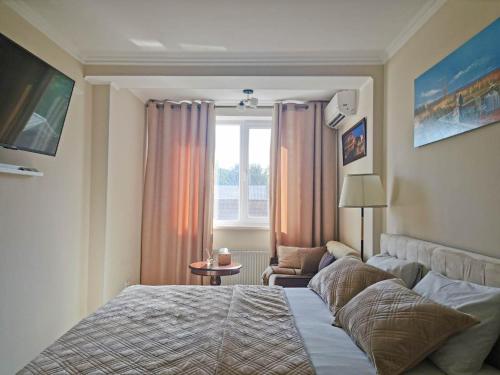 Lovely central 1BR apartment with a balcony في كيشيناو: غرفة نوم بسرير كبير ونافذة