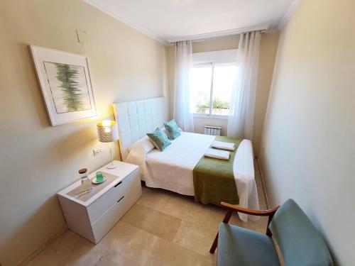 a small bedroom with a bed and a chair at Apartamento Gold Sierra Nevada in Granada