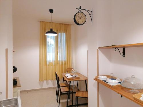 cocina con mesa y reloj en la pared en FarmaMia, en Ascea