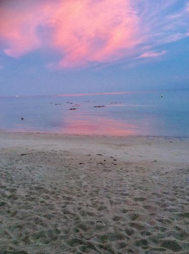 a beach with a pink sky and the water at Beer's House Bungalows เบียร์เฮ้าส์บังกะโล in Ban Lamai