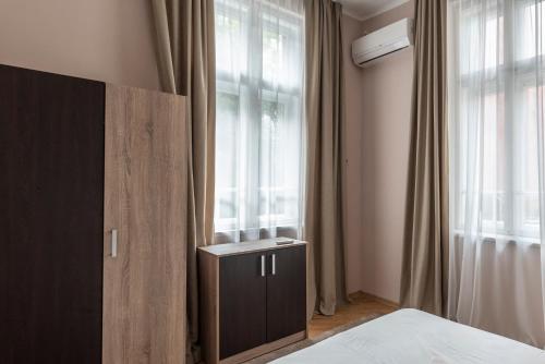 a bedroom with a bed and a window at Luxury Apart Vitosha Boulevard in Sofia