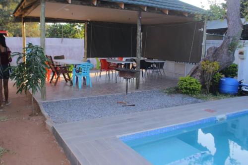 a backyard with a pool and a table and chairs at Universe GuestHouse in Kasane