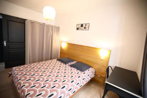 Schlafzimmer mit einem Bett mit einem Kopfteil aus Holz und einem Tisch in der Unterkunft Villa Pitaya in Le Tampon