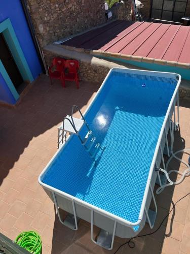 a blue pool sitting on a patio with two red chairs at Hotel Boutique Malanquilla Inedita in Malanquilla