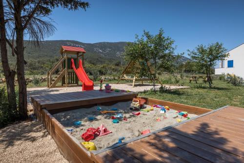 a sandbox with a slide and a play set at Hotel Manora in Nerezine