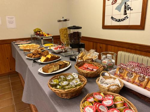 a long table with baskets of food on it at Hotel Capitán in Cangas de Onís