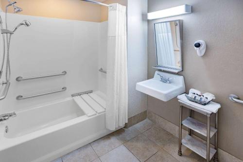 a bathroom with a bath tub and a sink and a bath tub at Microtel Inn & Suites by Wyndham Johnstown in Johnstown