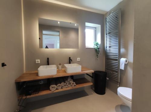 a bathroom with two sinks and a mirror at Vakantiewoning Sjun Limburg in Simpelveld