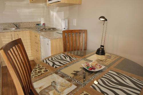 a dining room table with a plate of food on it at Big Five Motel in Palmerston North