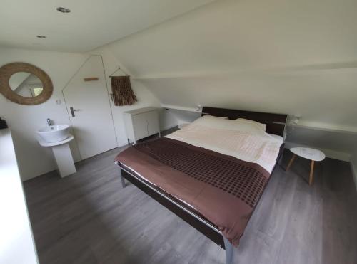a small bedroom with a bed and a sink at Vakantiewoning Sjun Limburg in Simpelveld